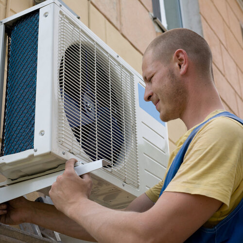 worker installing an outdoor air conditioning unit