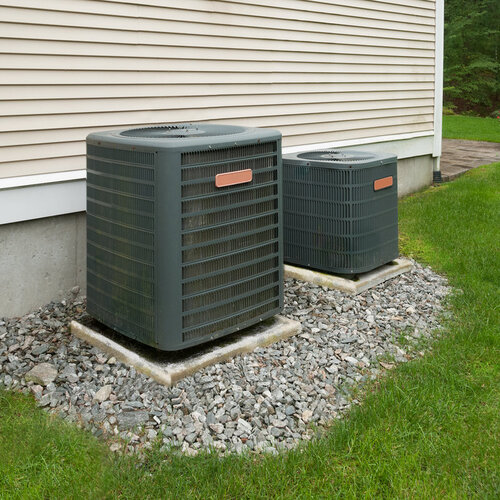 pair of air conditioning units sitting outside